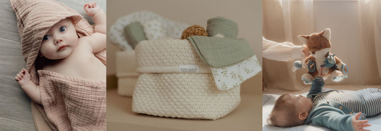 baby i håndklæde, hvide puslekurve og baby der ser på aktivitetsbamse med ræv og blå detaljer, gode barselsgaver hos Nordic Simply