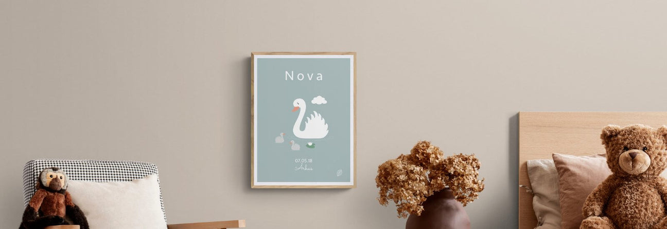 Blå navneplakat til barn med svane samt barnets  navn, fødselsdato og by, set på lys væg i børneværelse, design Nordic Simply