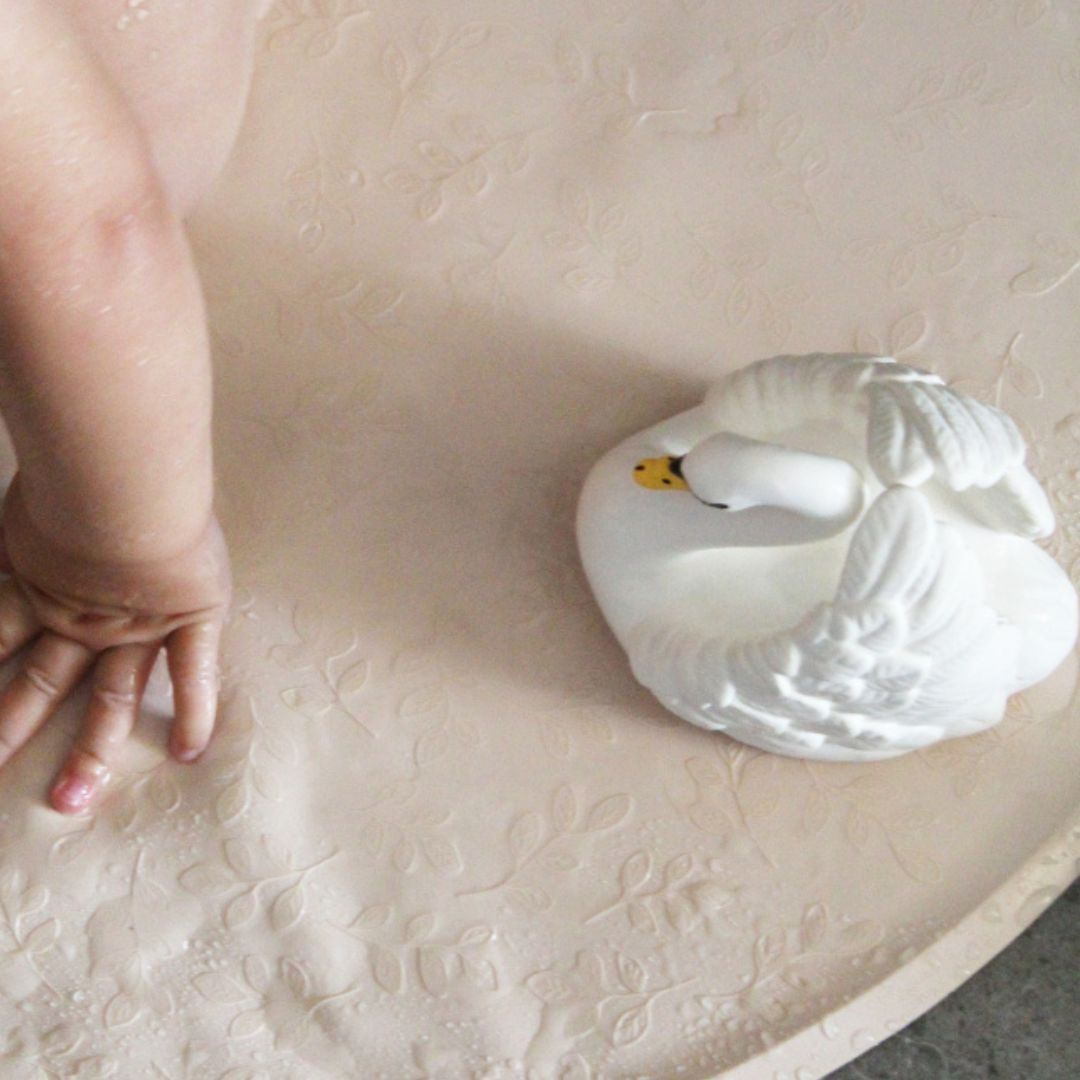 Stor hvid badesvane i naturgummi, set på rund bademåtte, fra Natruba fås hos Nordic Simply