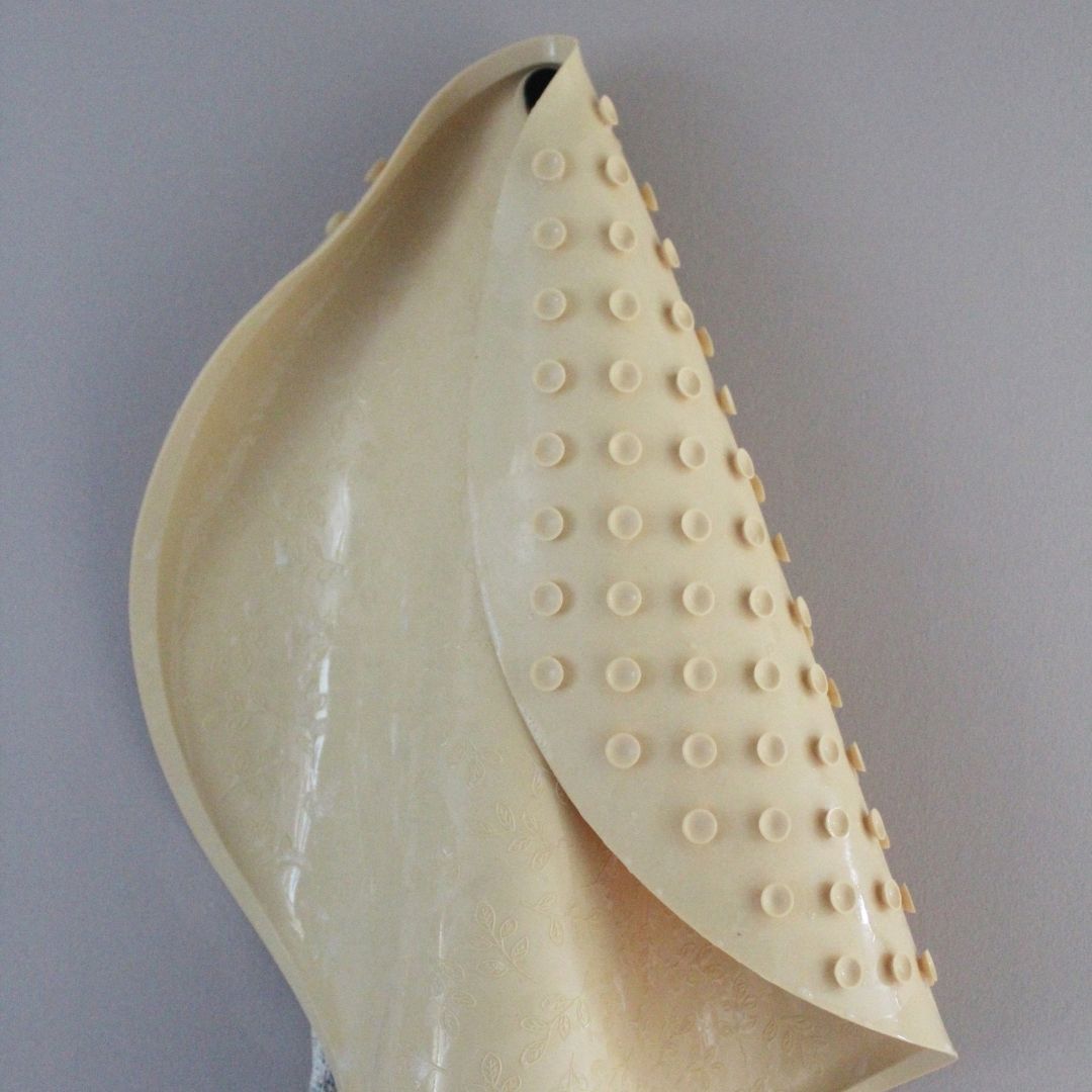 Rund gul bademåtte lavet i naturgummi fra Natruba hænger til tørre på knage, fås hos Nordic Simply