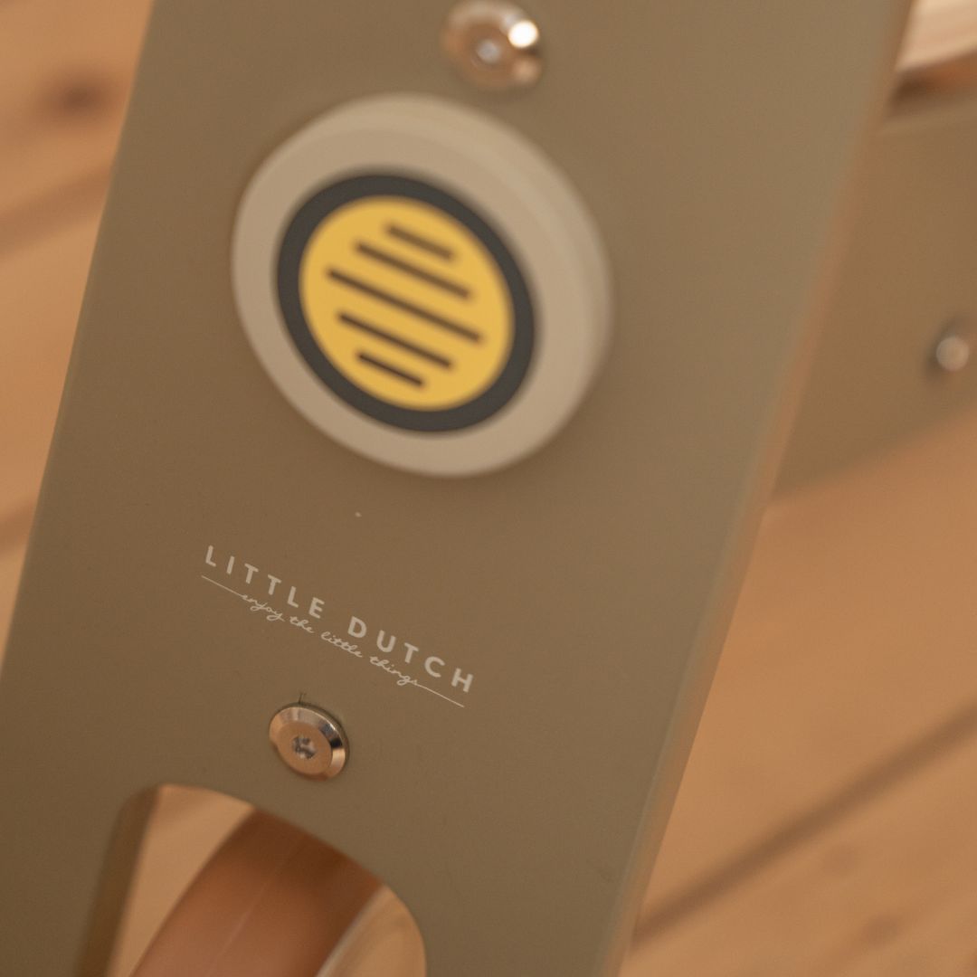 oliven-farvet balancecykel i træ fra Little Dutch, set tæt på, fås hos Nordic Simply
