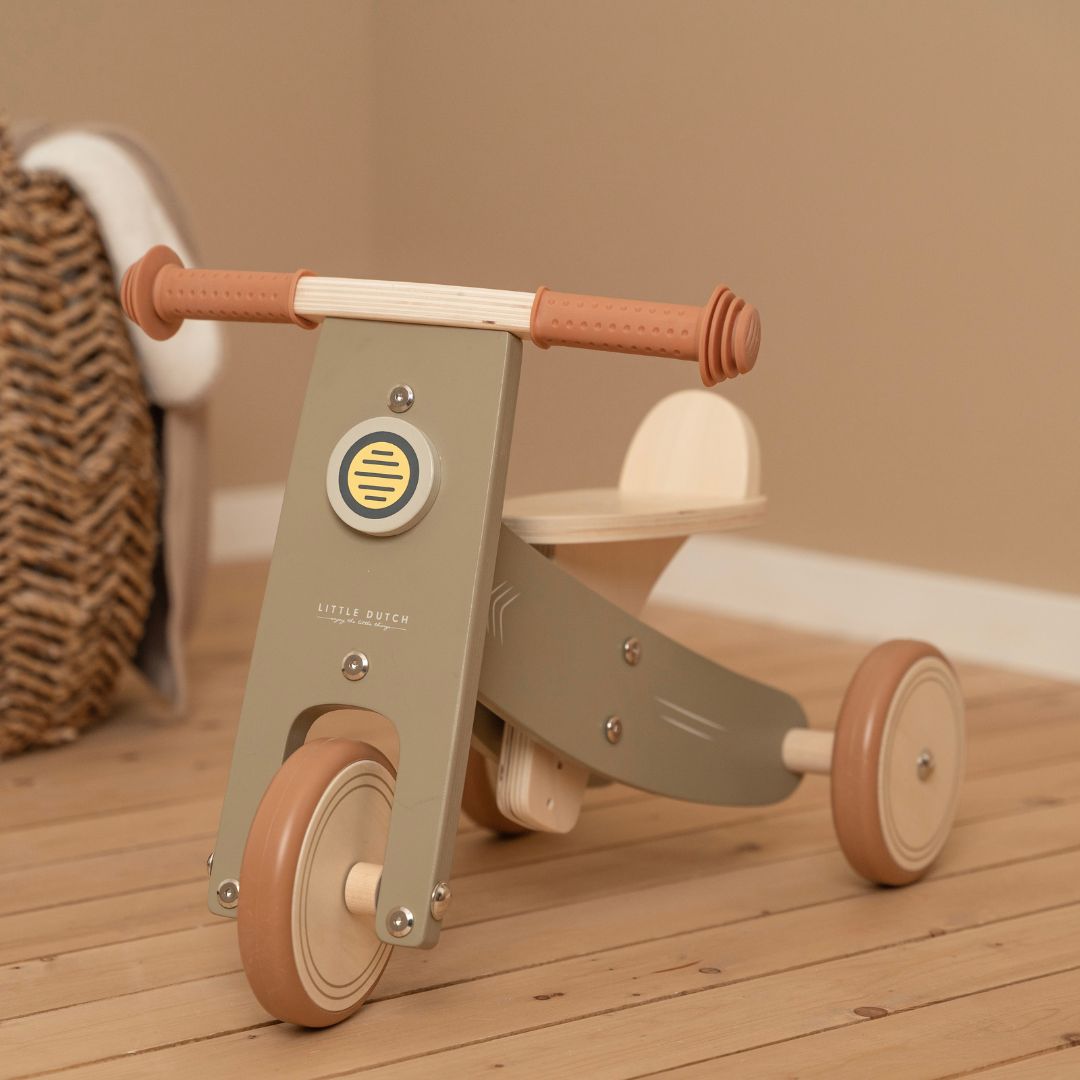 oliven-farvet trehjulet balancecykel i træ fra Little Dutch, står på trægulv, fås hos Nordic Simply