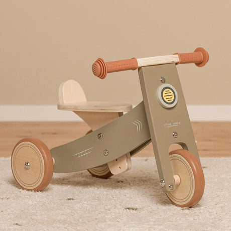 Oliven-farvet trehjulet balancecykel i træ fra Little Dutch til børn fra 18 måneder, hjælper med balance og koordination.
