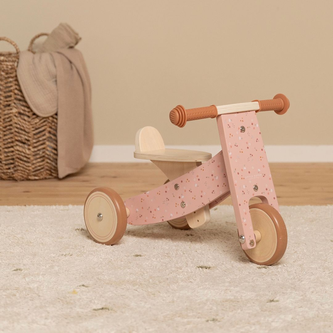 Trehjulet rosa balancecykel i træ fra Little Dutch, står på lyst tæppe i værelse