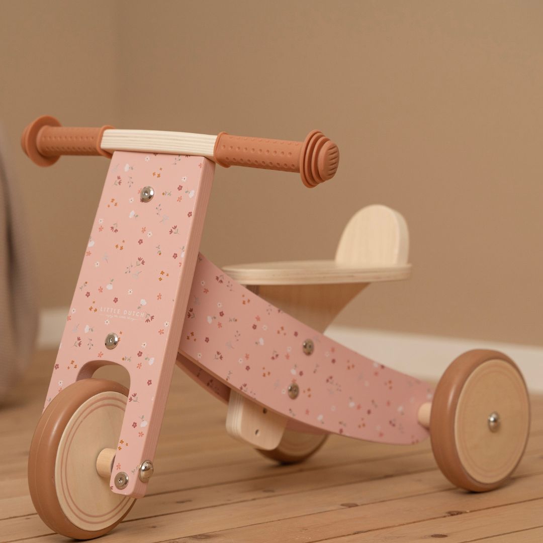 Trehjulet rosa balancecykel i træ til børn fra 18 måneder fra Little Dutch, står på trægulv, fås hos Nordic Simply