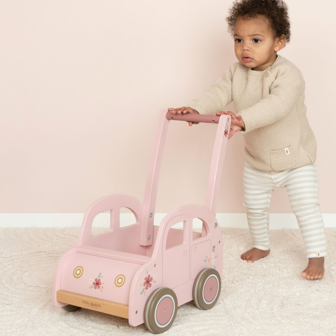 barn skubber rosa gåvogn fra Little Dutch formet som en folkevognsbobbel på lyst gulvtæppe.