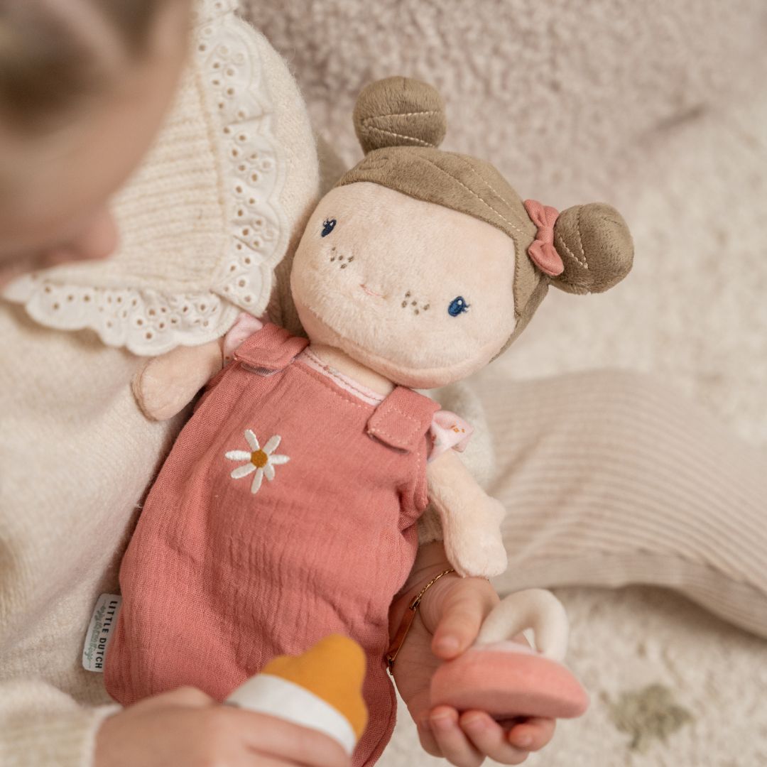 Lille blød dukke Rosa klædt i lyserød, perfekt til leg for børn fra 1 år, med sutteflaske og kram.