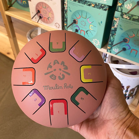 Rosa sansetromme fra Moulin Roty holdes i hånd hos Nordic Simply