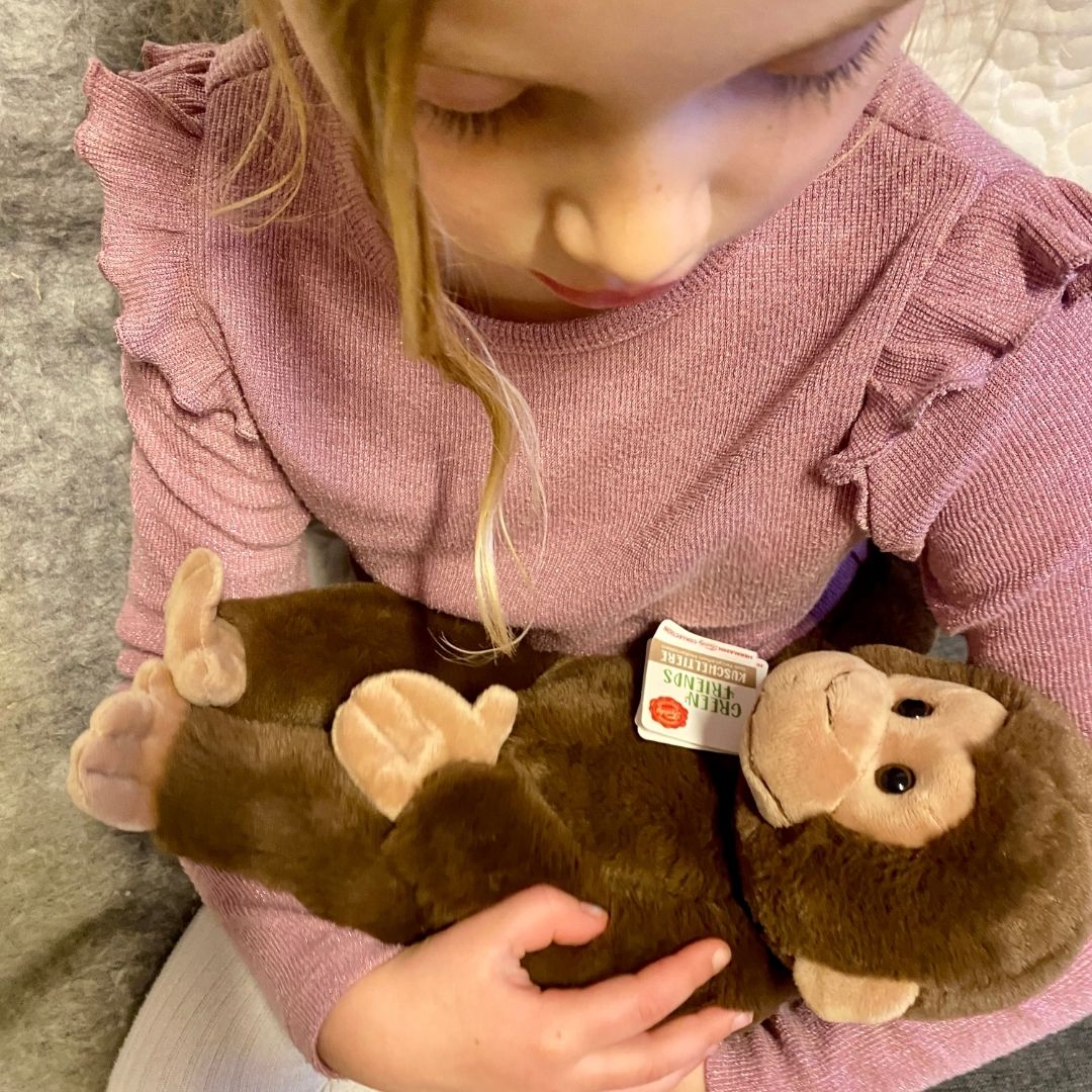 Pige sidder med blød abebamse i armene. Kvalitetsbamse fra Teddy Hermann godkendt fra 0 mdr. fås hos Nordic Simply