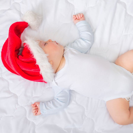 baby pige sover med nissehue på,  find adventskalender til baby pige 0-1 år hos Nordic Simply.