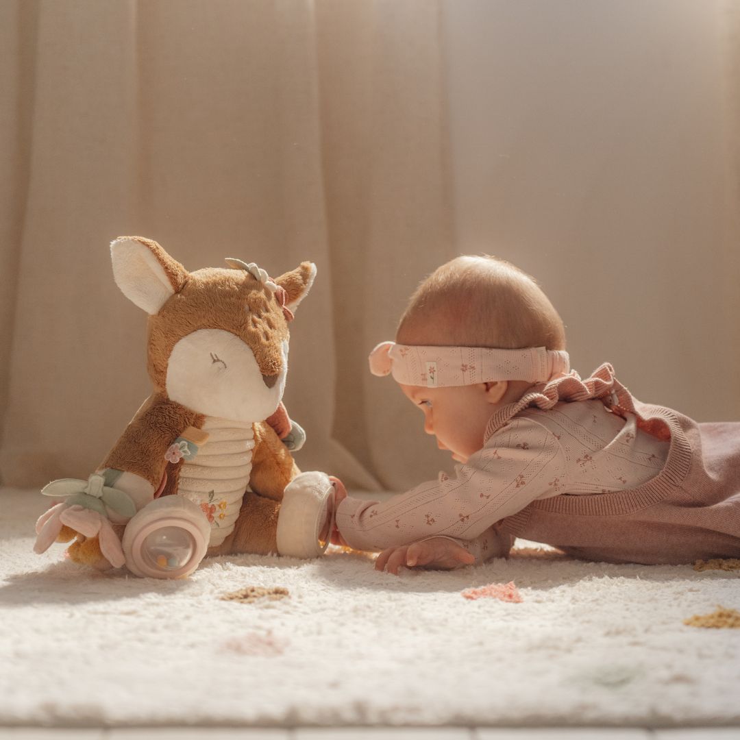 Baby pige leger med aktivitetsbamse rådyr fra Little Dutch med sjove teksturer og lyde i værelse, fås hos Nordic Simply.