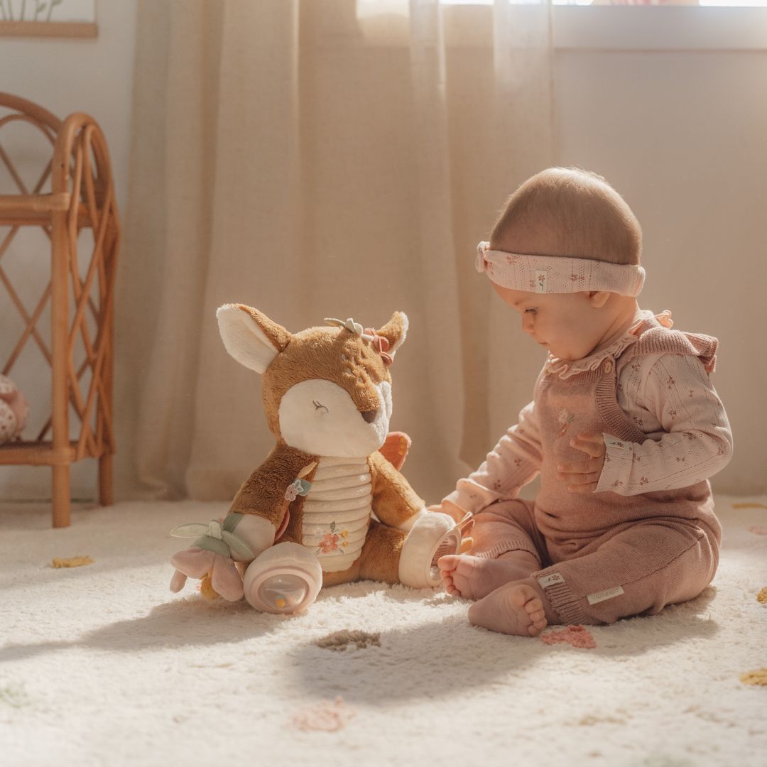 Baby sidder på gulvtæppe med aktivitetsbamse rådyr fra Little Dutch med sjove teksturer og lyde, fås hos Nordic Simply.