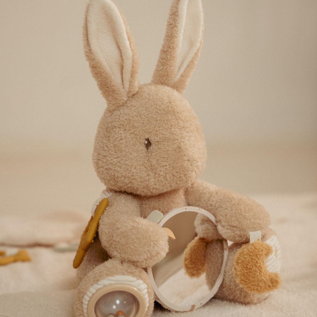 Beige aktivitetsbamse kanin med rundt spejl, sidder på lyst tæppe med lys baggrund, set fra siden, fås hos Nordic Simply