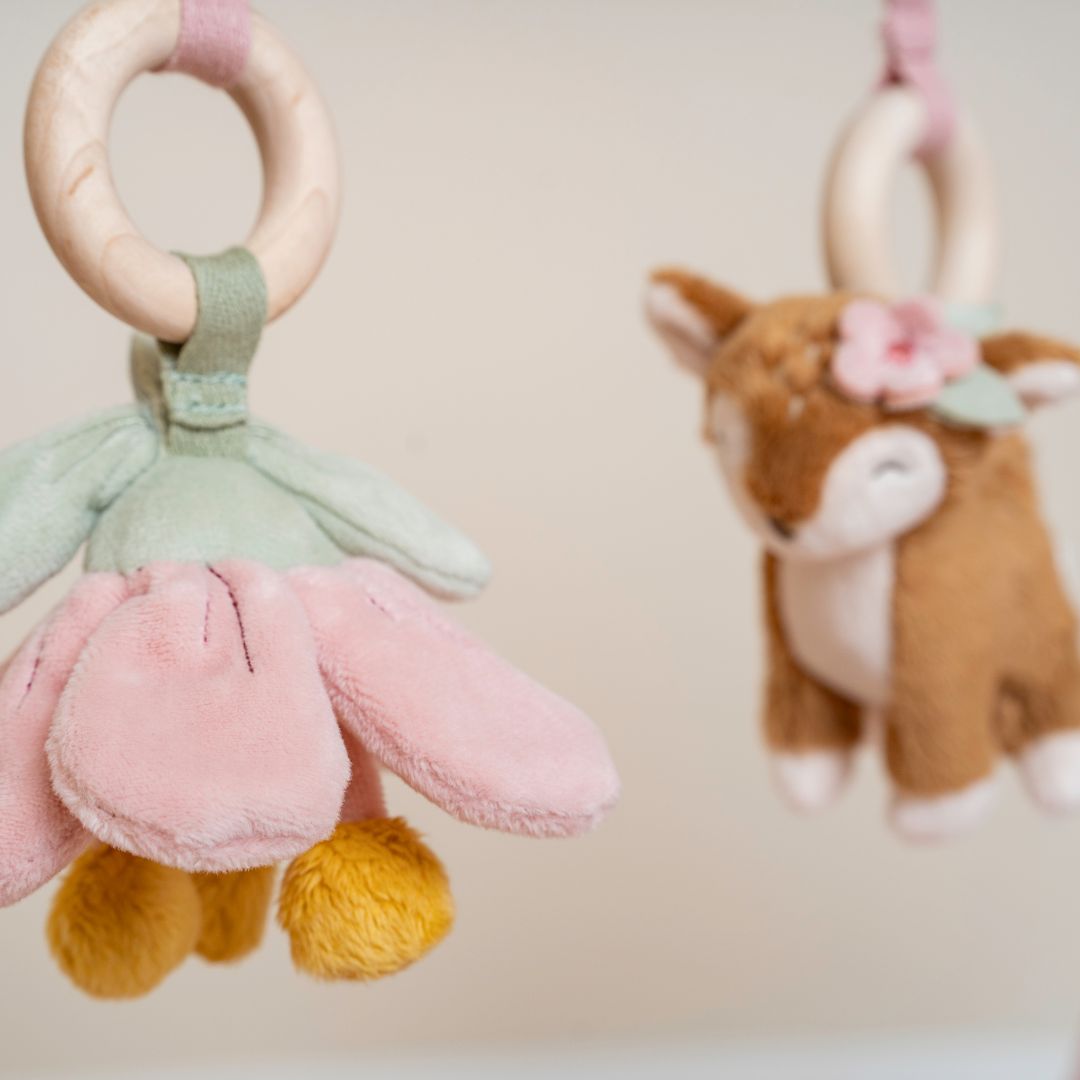 legetøj der hører med til aktivitetsstativ i træ til baby med rosa detaljer, her er det blomst og rådyr.