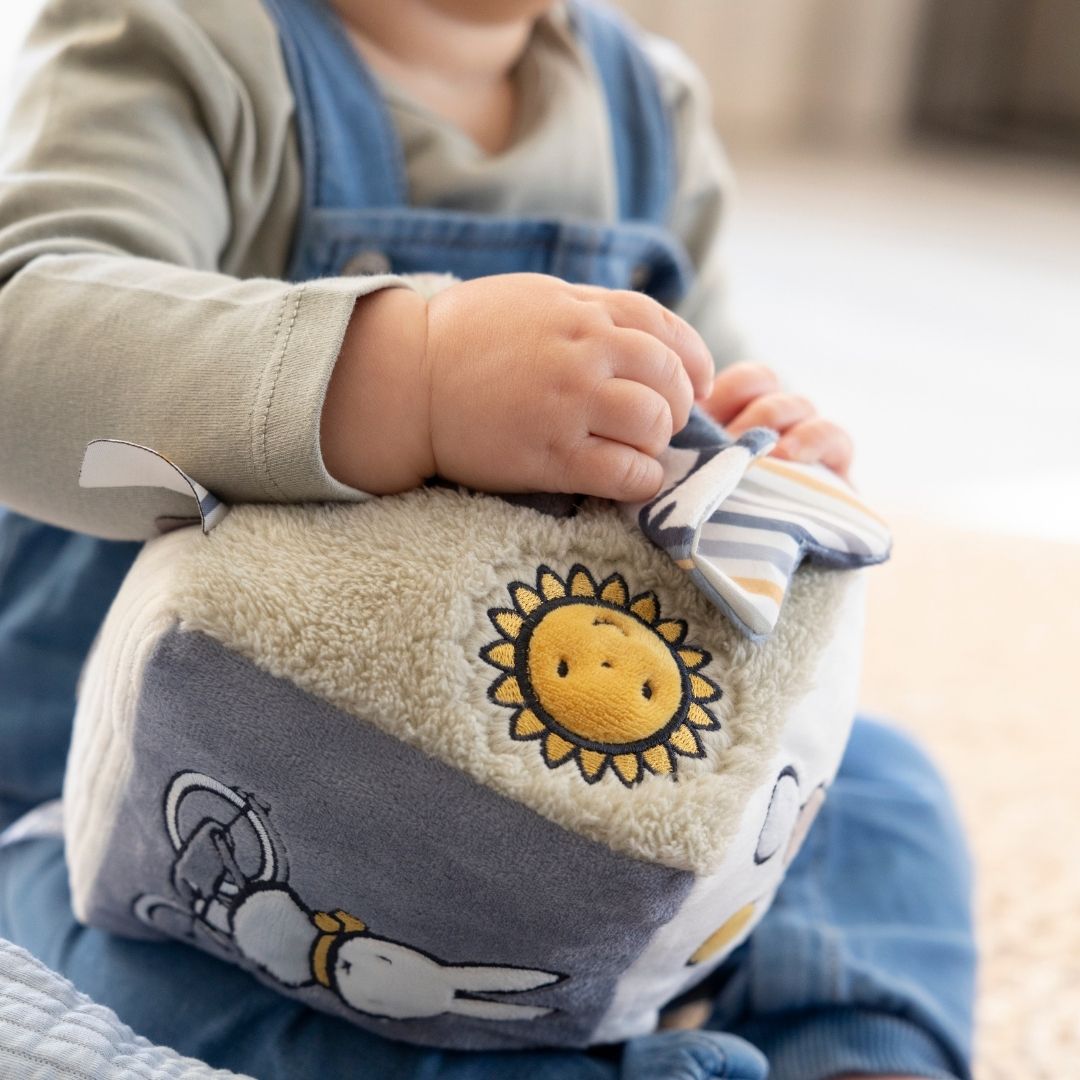 Aktivitetsterning til baby | Kanin blå - En baby leger med en farverig aktivitetsterning med sol og kaninmotiv.