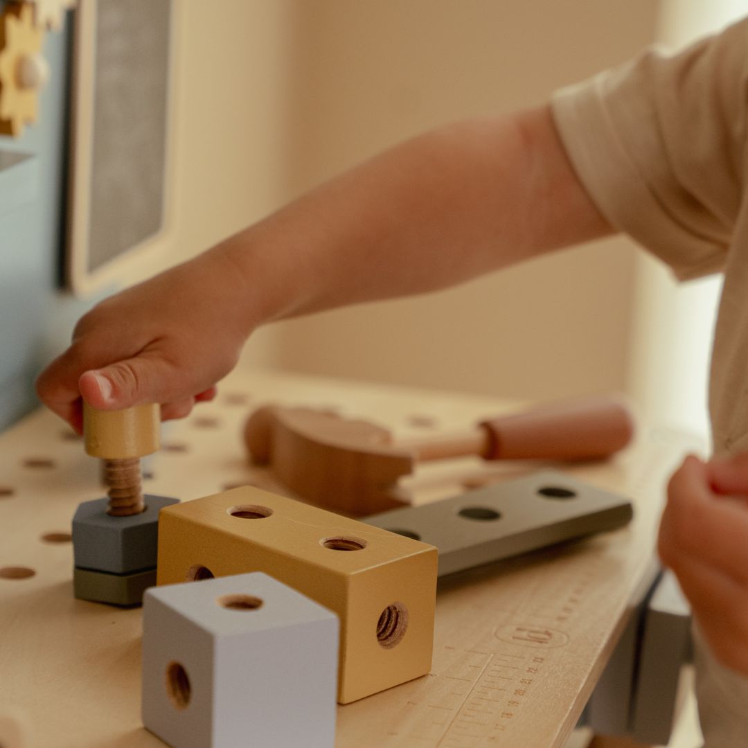 Barn leger ved stor blå arbejdsbænk i træ med masser af værktøj fra Little Dutch, perfekt til rolle-og fantasileg for din lille håndværker, fås hos Nordic Simply