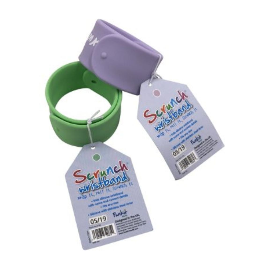 To klik-på armbånd fra Scrunch med felter til at skrive barnets navn og dit telefonnummer, perfekt til ferier, fås hos Nordic Simply