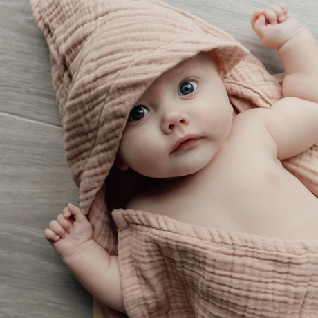 Baby i badehåndklæde med hætte i 100% økologisk rosa bomuld muslin fra Natruba fås hos Nordic Simply