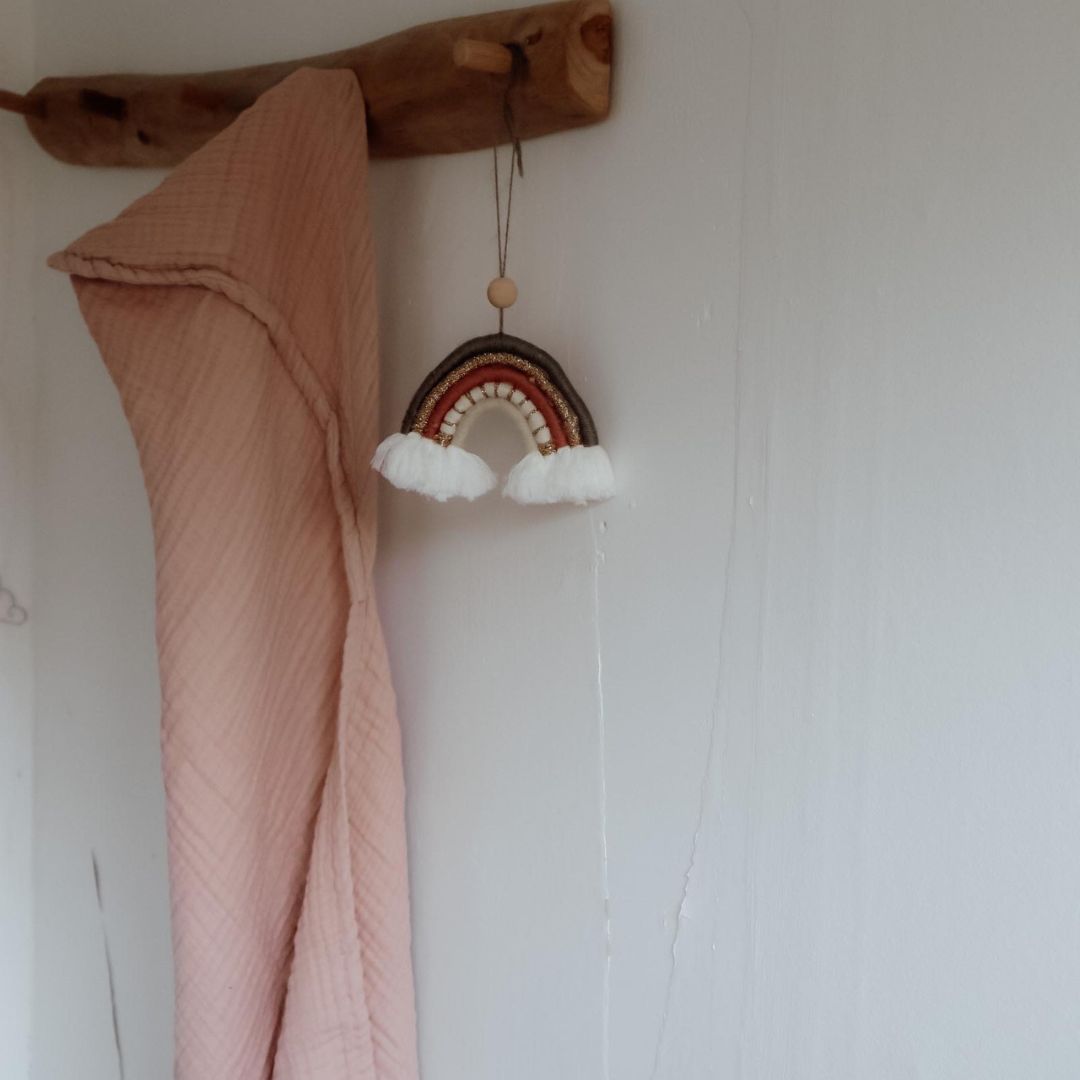 Badehåndklæde til baby med hætte i 100% økologisk rosa bomuld muslin fra Natruba, hænger på gammel knagerække i træ.