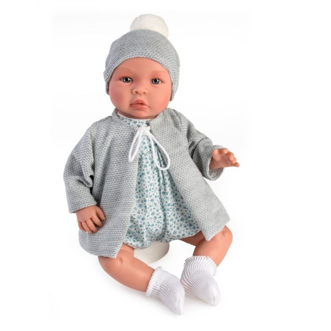 Stor håndlavet babydukke dreng Leo i grå jakke og hue med dragt af lyst liberty stof med små blå blomster og hvide sokker, fra Así fås hos Nordic Simply