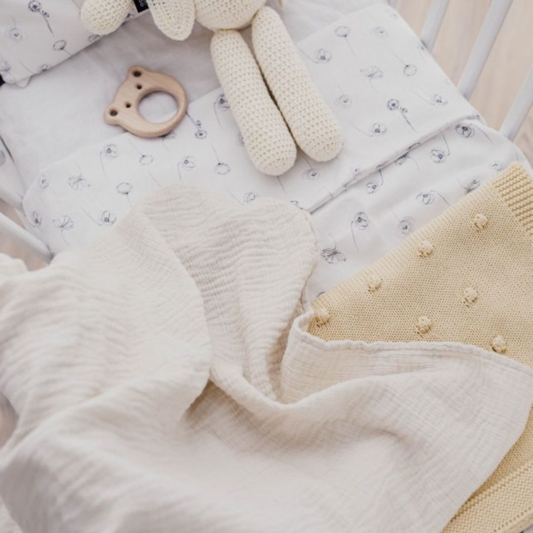 Babytæppe i elfenbensfarvet muslin, ligger i babyseng, 100% bomuld fra Ooh Noo fås hos Nordic Siply