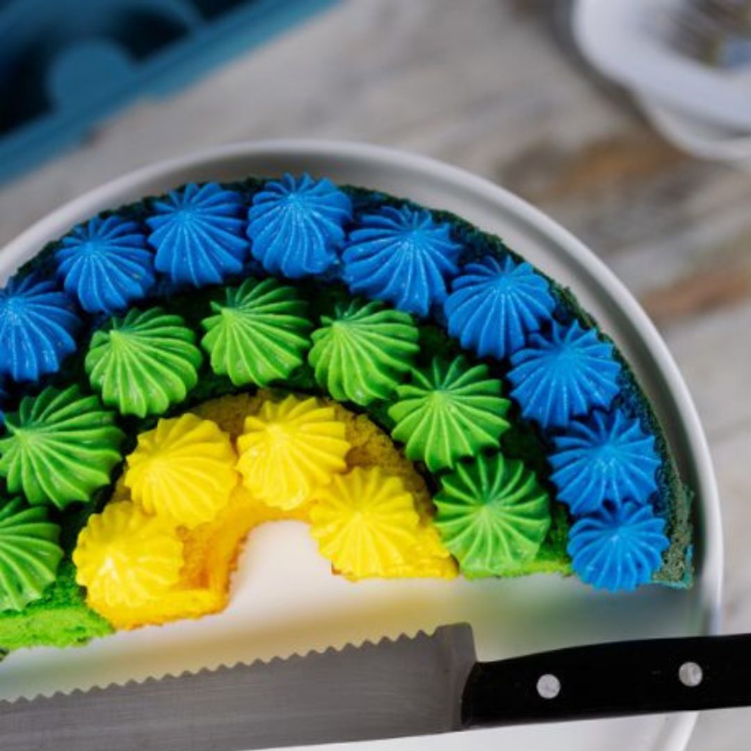 Regnbuekage i tre farver blå, grøn og gul, bagt i grøn regnbue bageform i silikone fra Dëna fås hos Nordic Simply