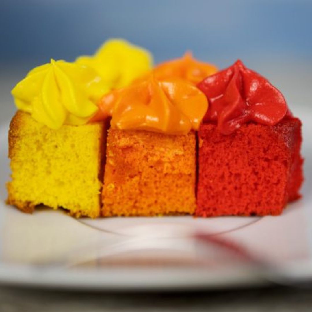 regnbuekage set i snit i tre farver rød, orange og gul, bagt i rosa regnbue bageform fra Dëna fås hos Nordic Simply