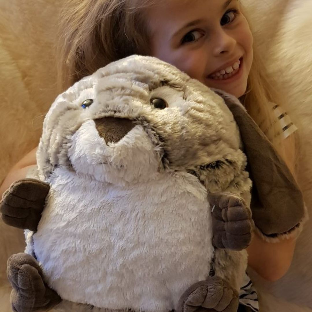 Pige med stor kanin bamse og håndvarmer i én fra Cozytime, en lun bamse i størrelse XL, fås hos Nordic Simply.