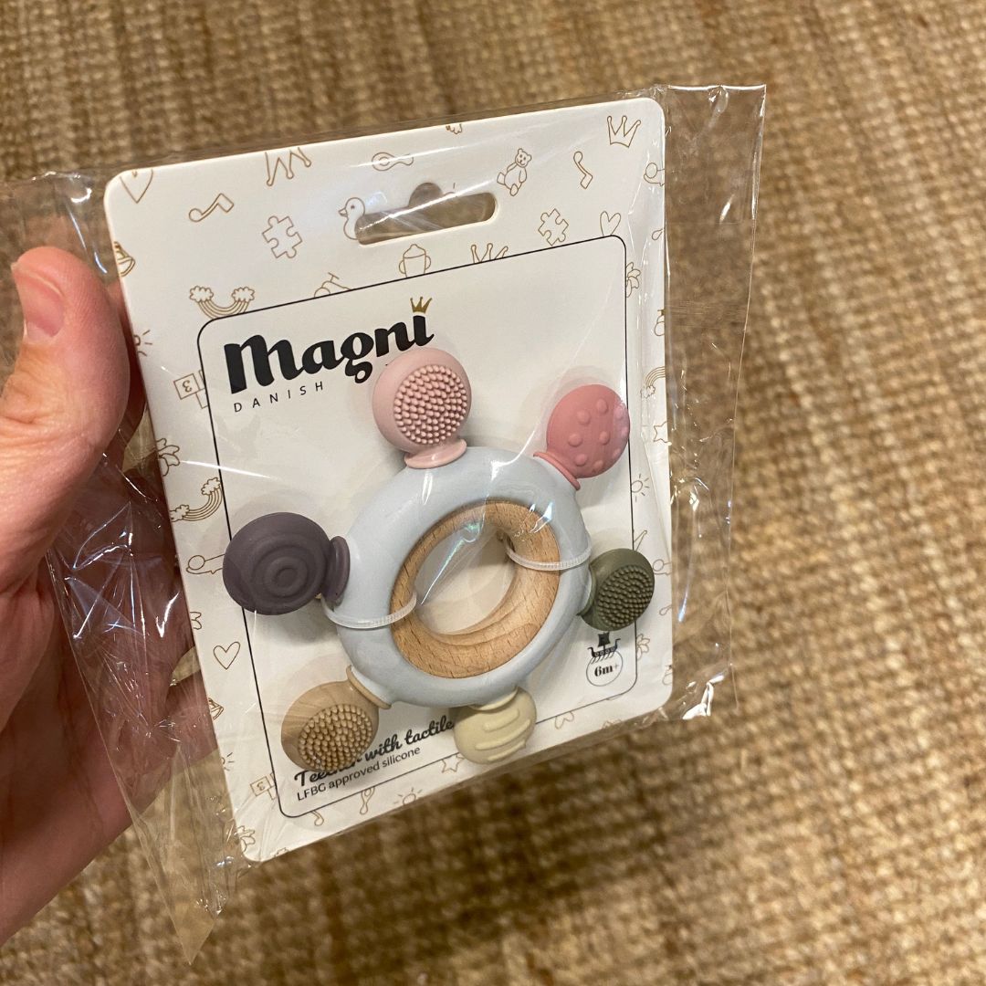 Multifarvet bidering i silikone på træring fra Magni, set i emballage, hos Nordic Simply