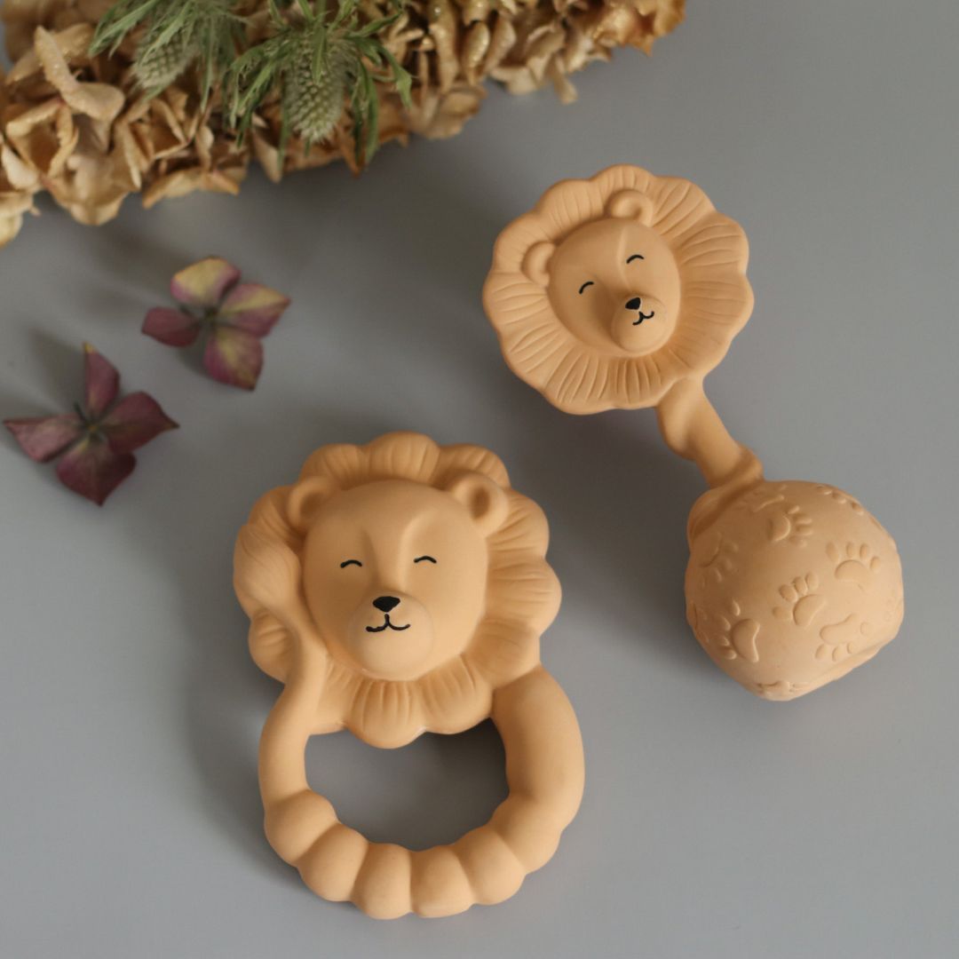 Beige bidering og rangle formet som løver i naturgummi fra Natruba, set på grå baggrund, fås hos Nordic Simply