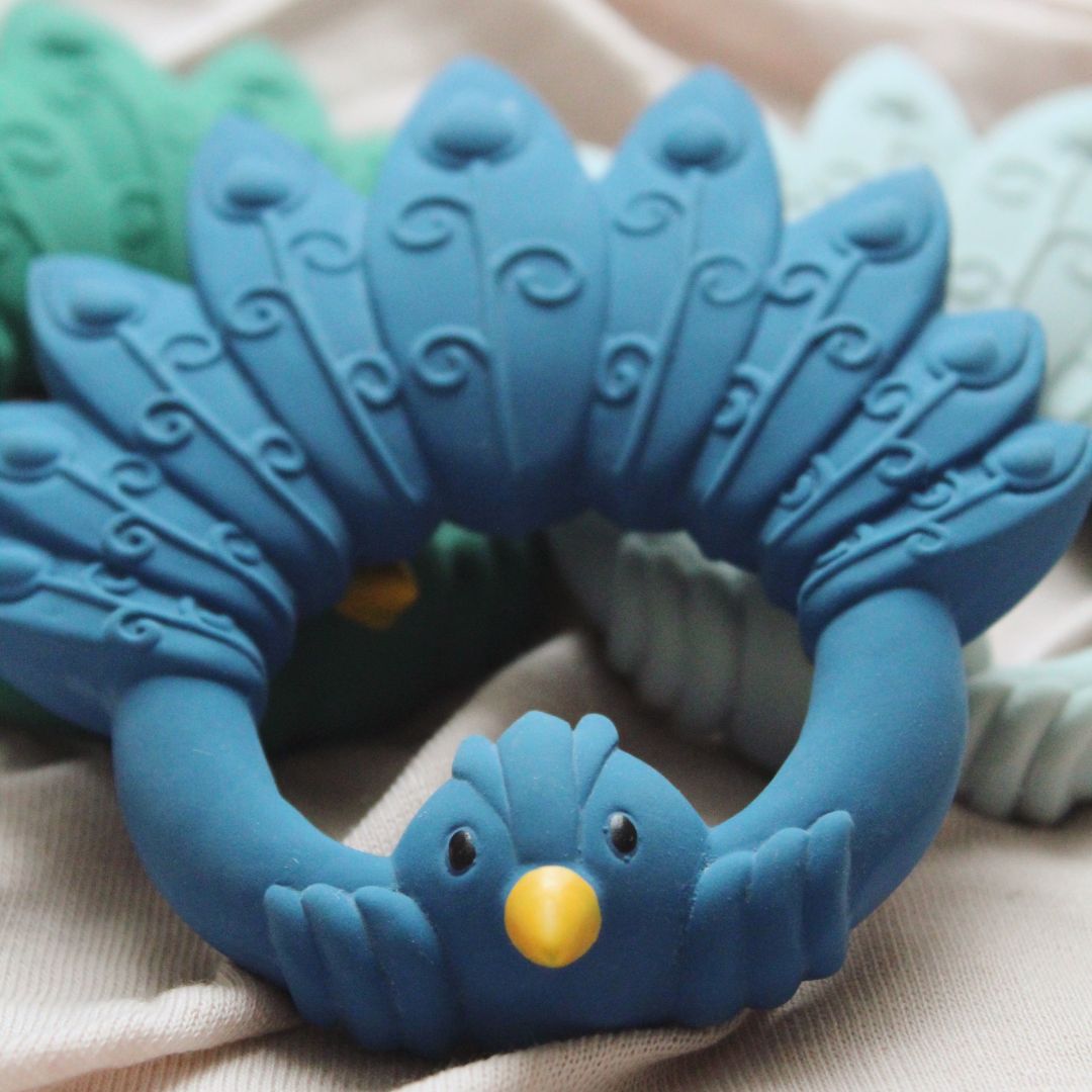 Blå bidering formet som en påfugl i naturgummi fra Natruba , ligger på tæppe, fås hos Nordic Simply