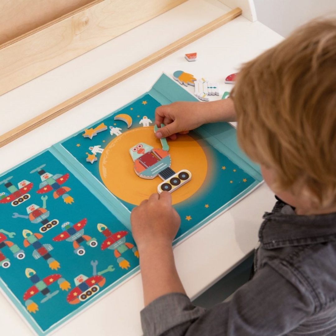 Barn sætter magneter i bog med figurer fra rummet fra Scratch, god til fordybelse, finmotorik og koncentration, fås hos Nordic Simply