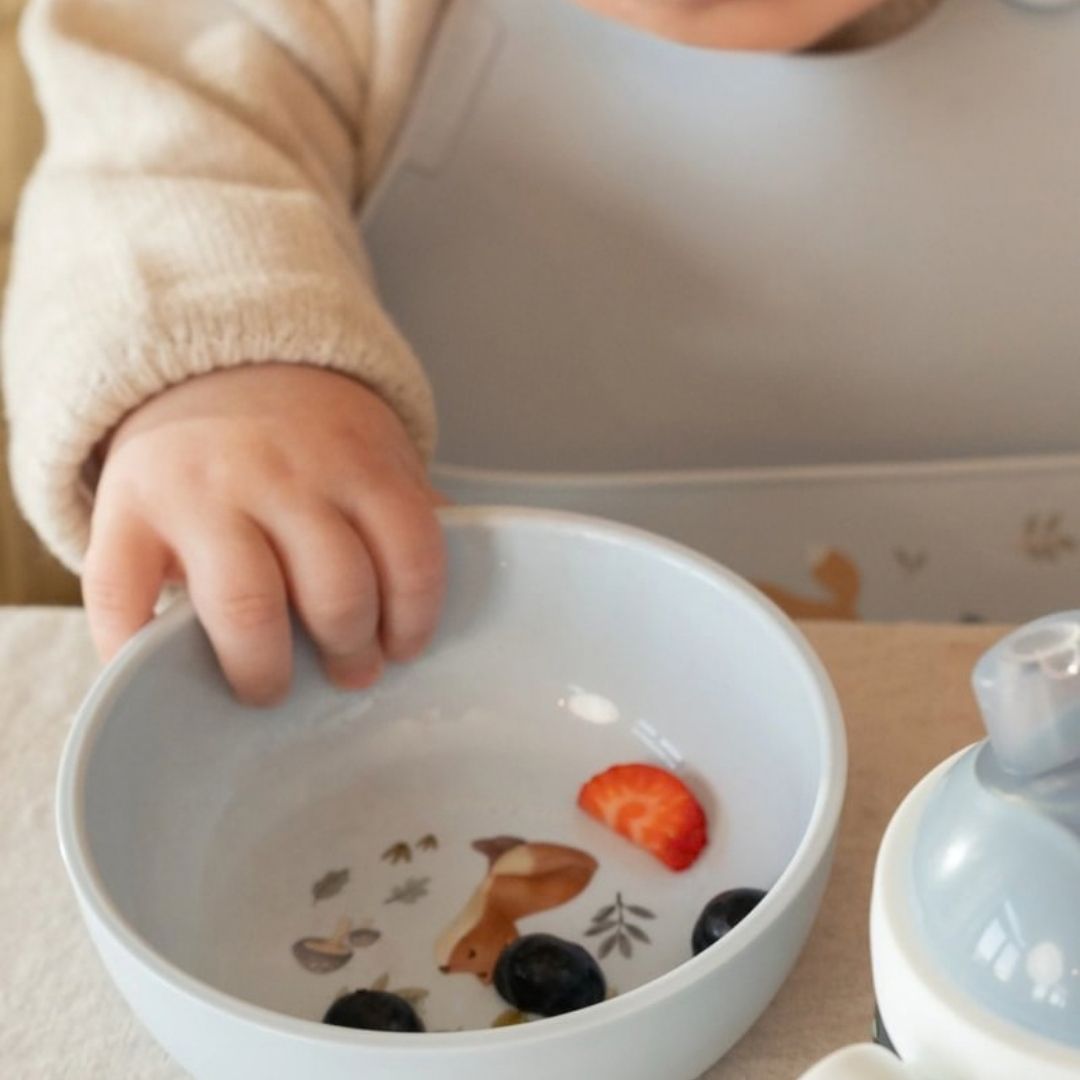 blå børneskål med motiv af ræv, god til grød, mos, bær og snacks fra Mepal x Little Dutch. Her set med børnehænder der tager blåbær fra den.