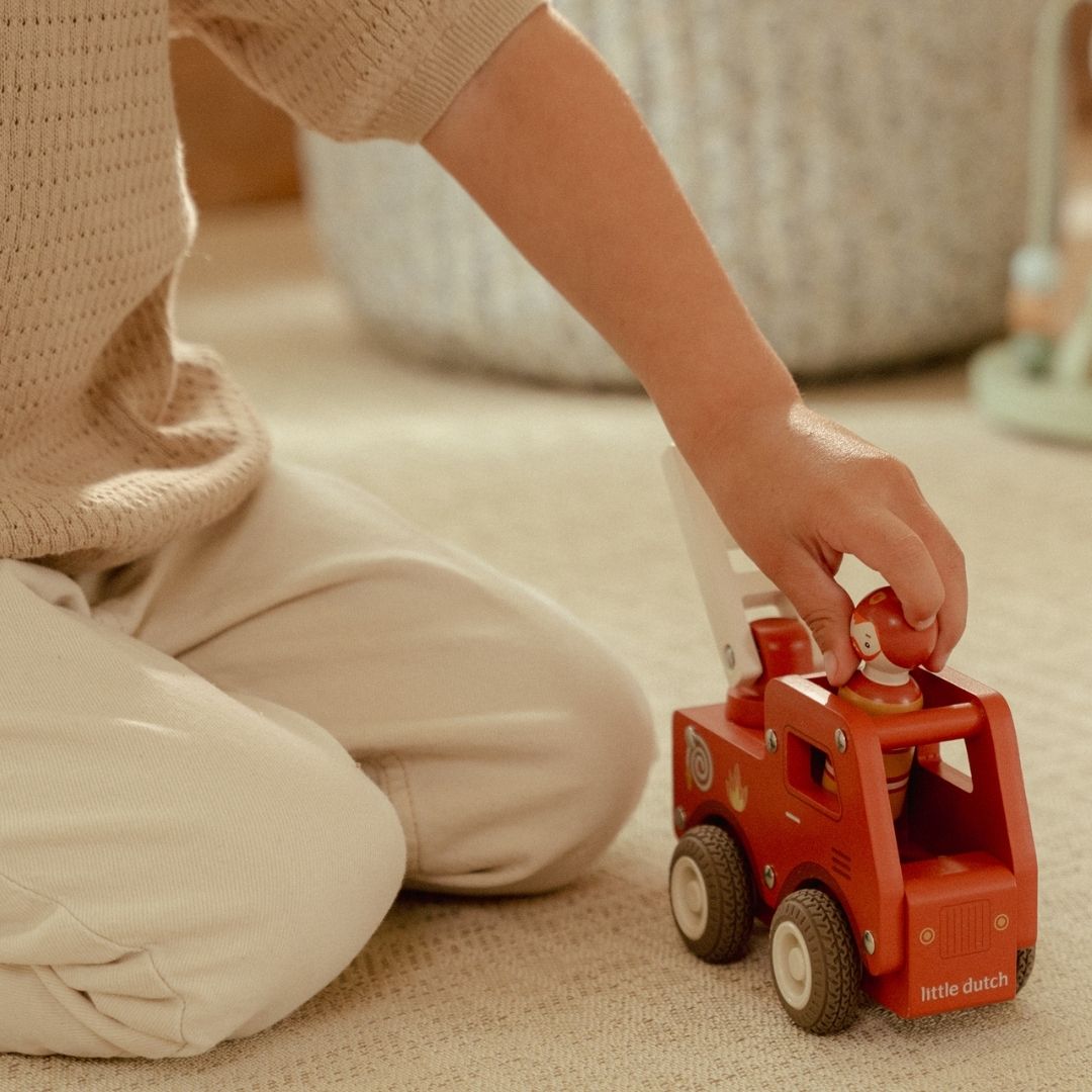 Brandbil med træfigur: Barn leger med en rød træbrandbil fra Little Dutch med en modig brandmand.