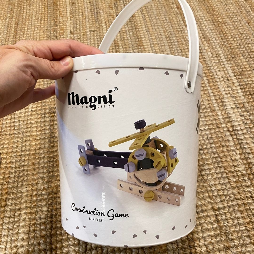 Hånd holder spand med byggesæt i træ til børn med 80 dele fra Magni fås hos Nordic Simply