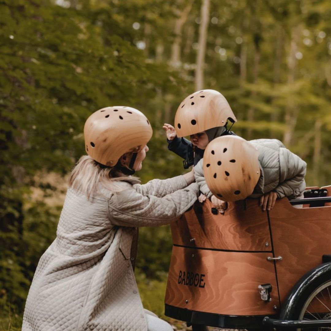 Mor og børn med cykelhjelm i træ look, cykelhjelm til børn 2-4 år og 4-8 år fås hos Nordic Simply