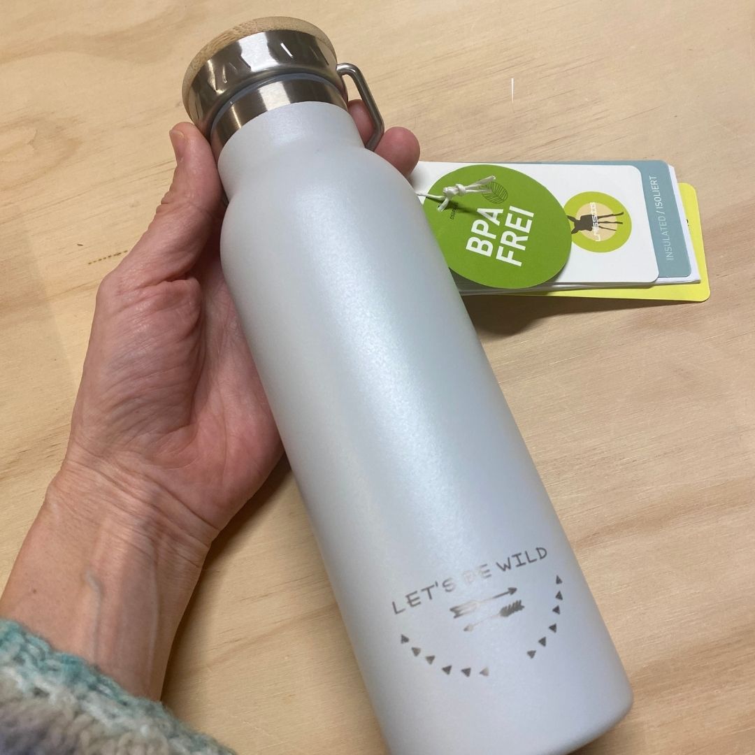 Hånd med termoflaske i rustfrit stål i lys grå med bambuslåg, indeholder 460 ml fra Lässig fås hos Nordic Simply