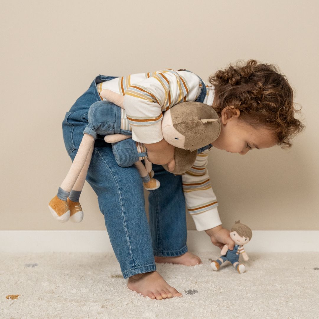 Barn leger med blød Jim dukke, som han holder i hånden, sjov leg og hygge for små børn.