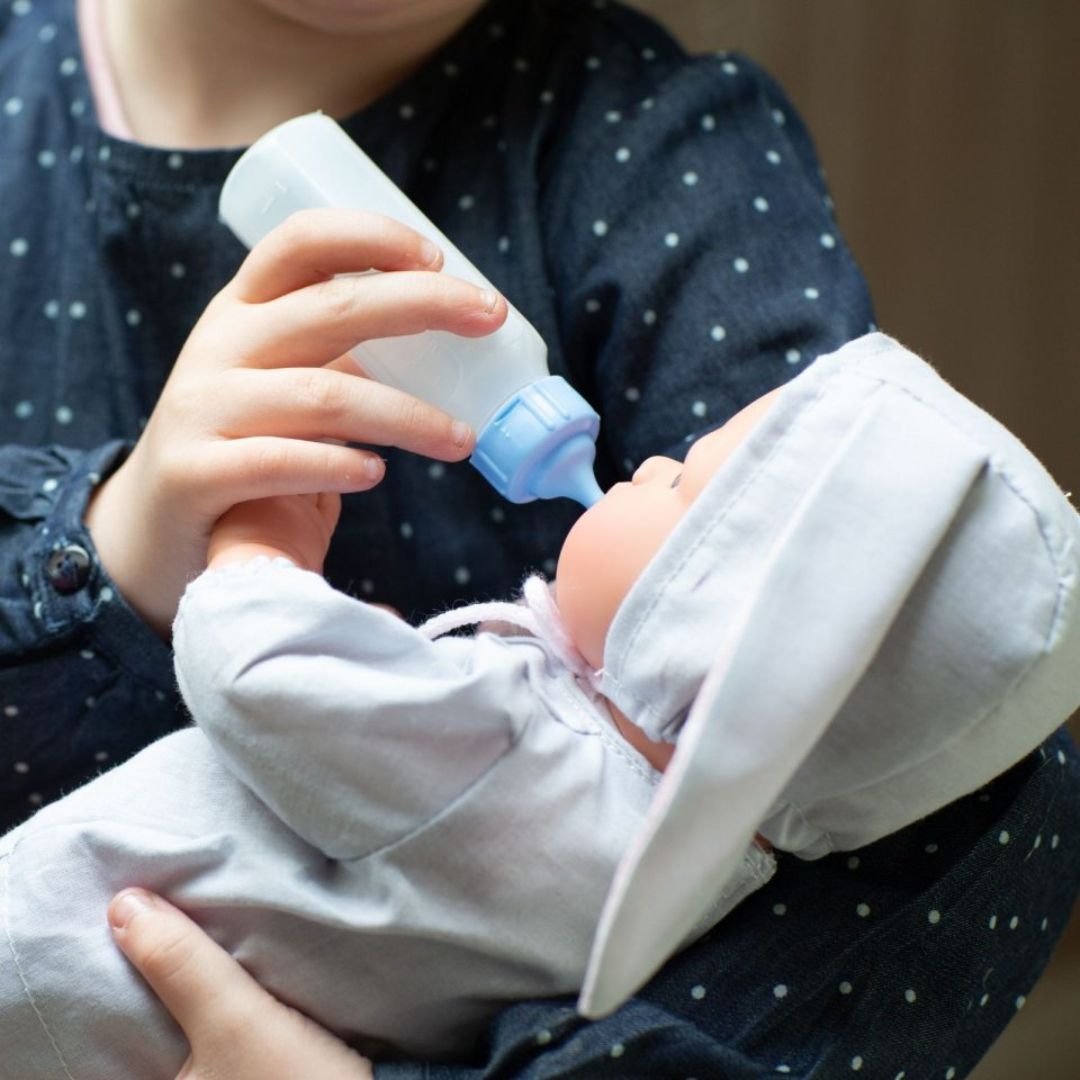 Pige giver dukke, i grå dragt med kaninører, sutteflaske. Koke dukke fra spanske Así fås hos Nordic Simply