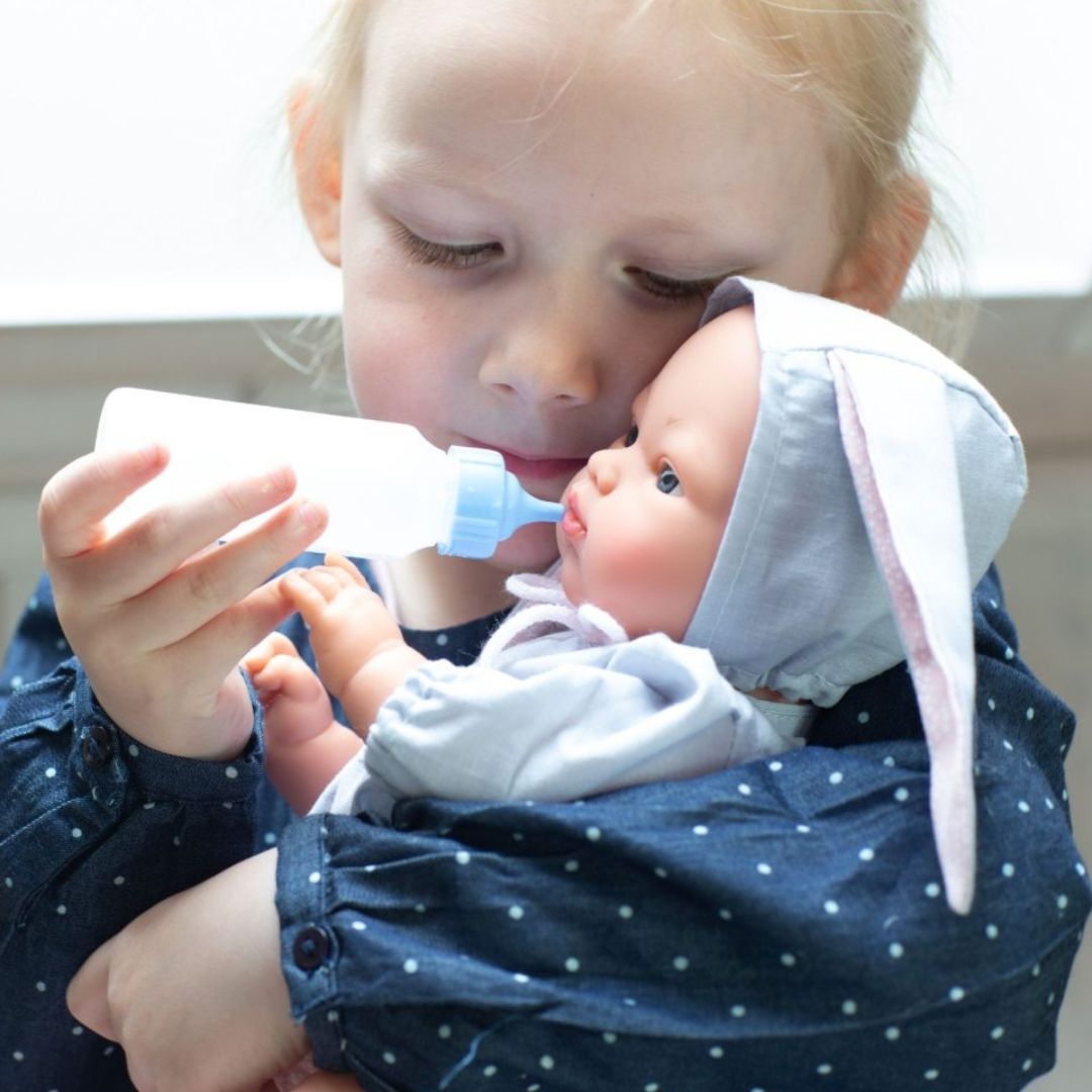 Pige mader dukke, i grå dragt med kaninører, med sutteflaske. Kvalitetsdukke fra spanske Así fås hos Nordic Simply