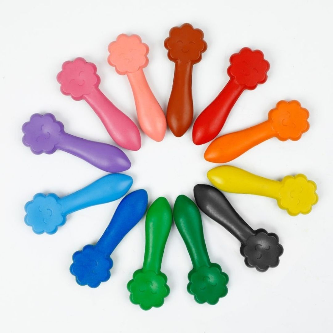 12 farver med smilende ansigter fra Haku Yoka lagt i en cirkel, børnevenlige farver med bivoks fås hos Nordic Simply