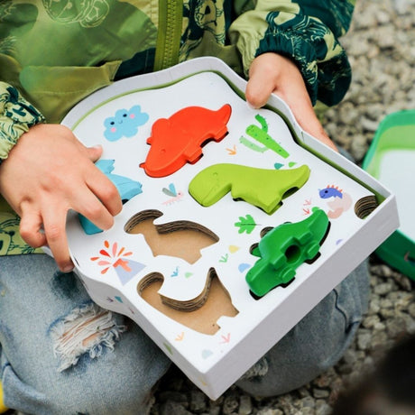 Barn holder æske med farverige dinosaur-formede fingerfarver fra Haku Yoka til børn, fås hos Nordic Simply
