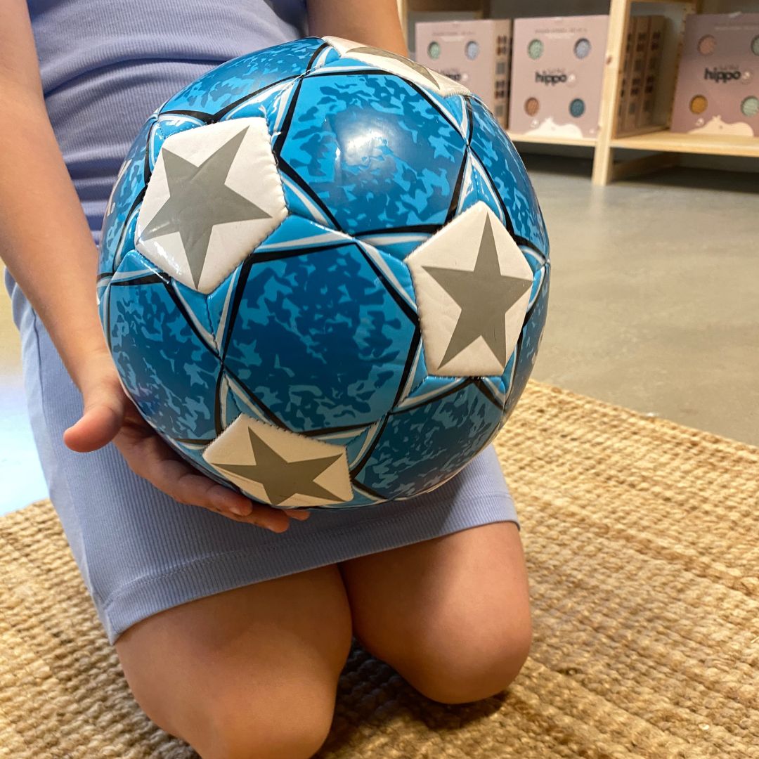 Barn holder blå fodbold fra SportX hos Nordic Simply