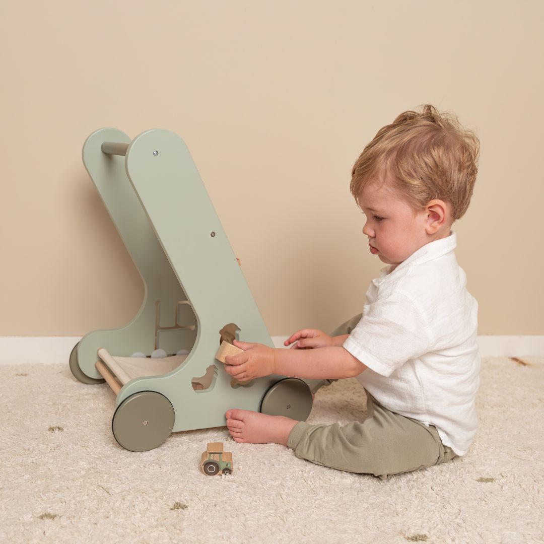 Barn leger ved grøn gåvogn i træ med 8 bondegårdsaktiviteter fra Little Dutch, fås hos Nordic Simply