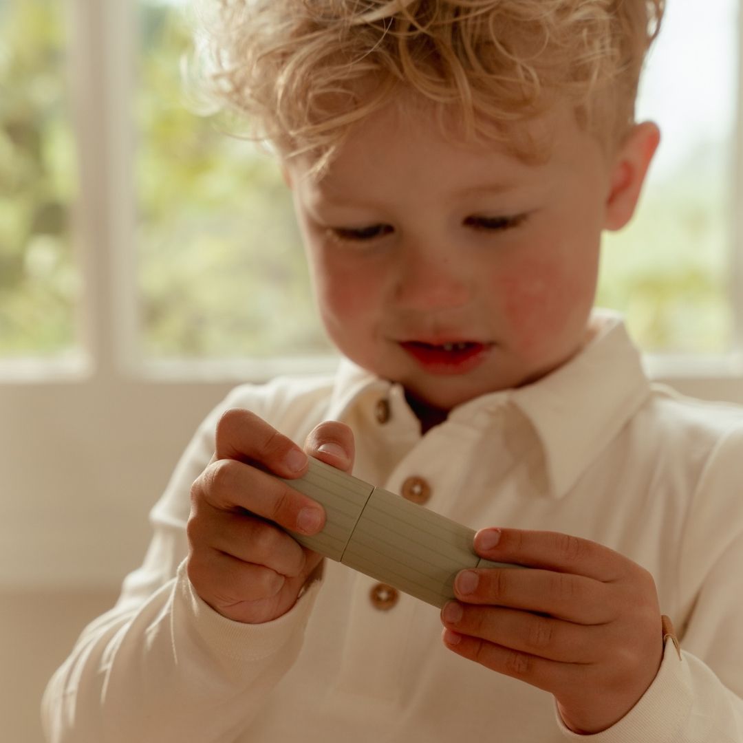 Dreng leger med agurk fra grøntsagssæt i træ fra Little Dutch, passer perfekt sammen med legekøkkenet i samme serie