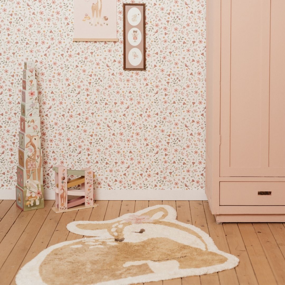 Lyst gulvtæppe med rådyr, legetæppe i økologisk bomuld, set i hyggeligt børneværelse med blomstret tapet og rosa skab.