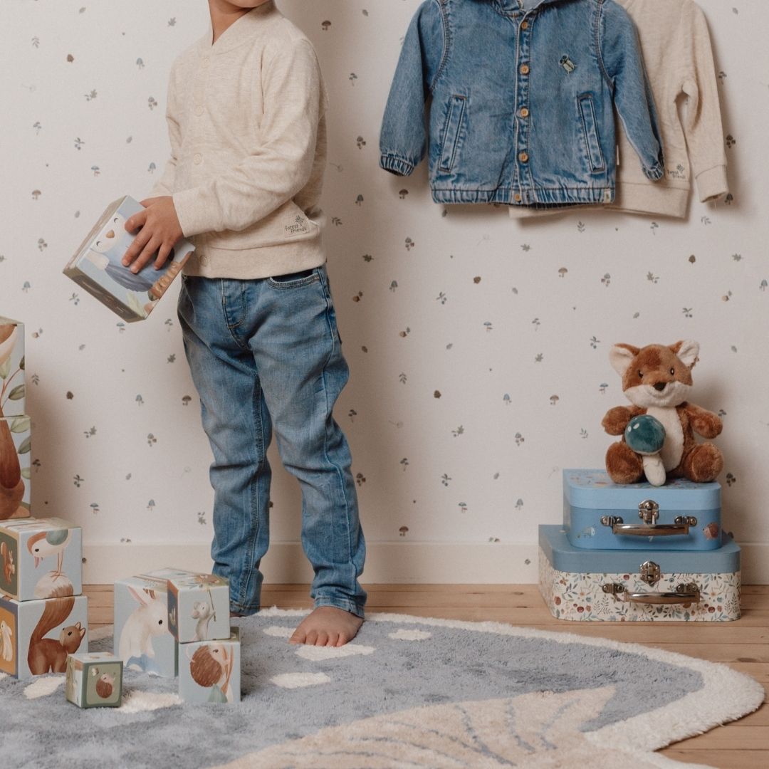 Svampe tæppe i blå, set i hyggeligt baby- og børneværelse med legende børn. Lavet i blød økologisk bomuld.