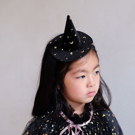 Pige med lille sort heksehat i sort velour med stjerner, sidder på hårbøjle fra Mimi & Lula fås hos Nordic Simply