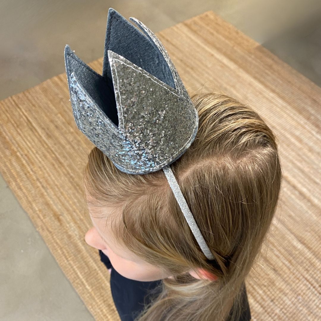 Pige, set oppefra, med sølvkrone på hårbøjle, perfekt til udklædning eller fest for børn fra 3 til 8 år fra Mimi & Lula fås hos Nordic Simply