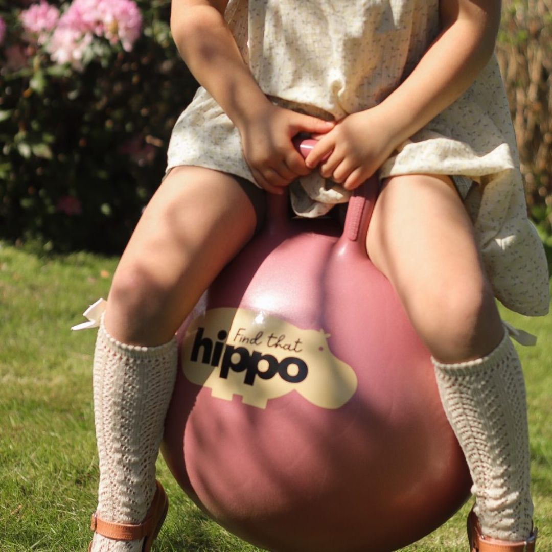 Barn leger ude på rosa hoppebold fra Find that Hippo til aktiv leg, motorik og balance, fås hos Nordic Simply.